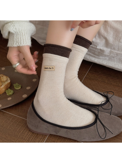 Ivory socks with dark brown rolled cuffs worn with bow-trim flats.