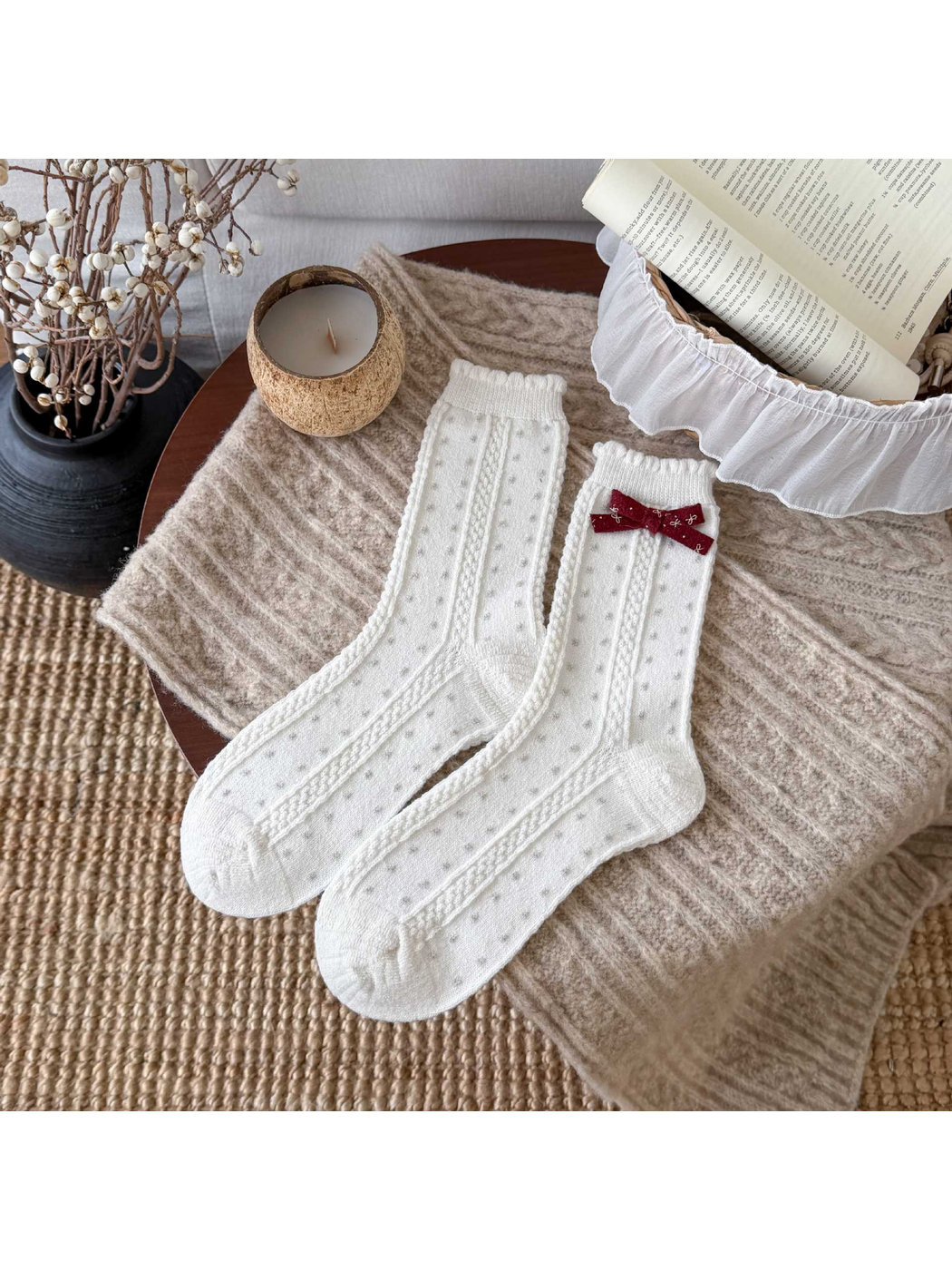 White socks with small gray dots, cable-textured bands, scalloped cuffs, and a burgundy bow.