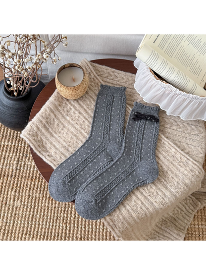 Dark Gray socks with small light dots, cable-textured bands, scalloped cuffs, and a black bow.