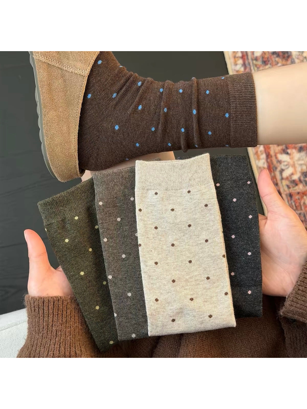 Folded polka dot socks held beneath a Coffee sock worn with a tan shoe.