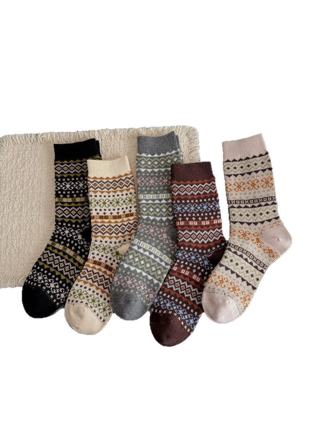 Five geometric-patterned crew socks arranged side by side in Black, Ivory, Gray, Brown and Greige.