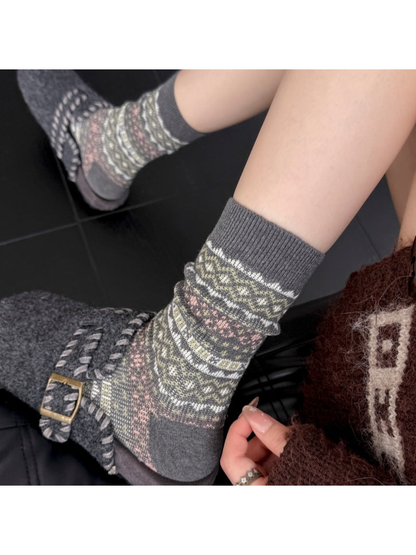 Close-up of Gray socks with ribbed cuffs and geometric bands worn with buckle slippers.