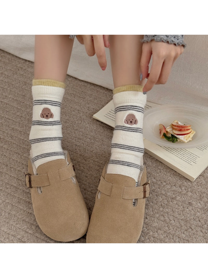 Ivory striped socks with dog faces and yellow cuff edging worn with tan clogs.