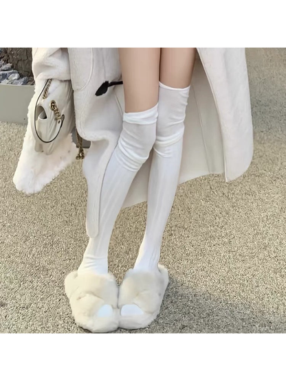 White socks with folded top cuffs worn with fluffy white slippers.