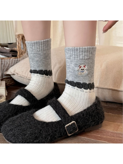 Gray and ivory socks worn with black buckled shoes.