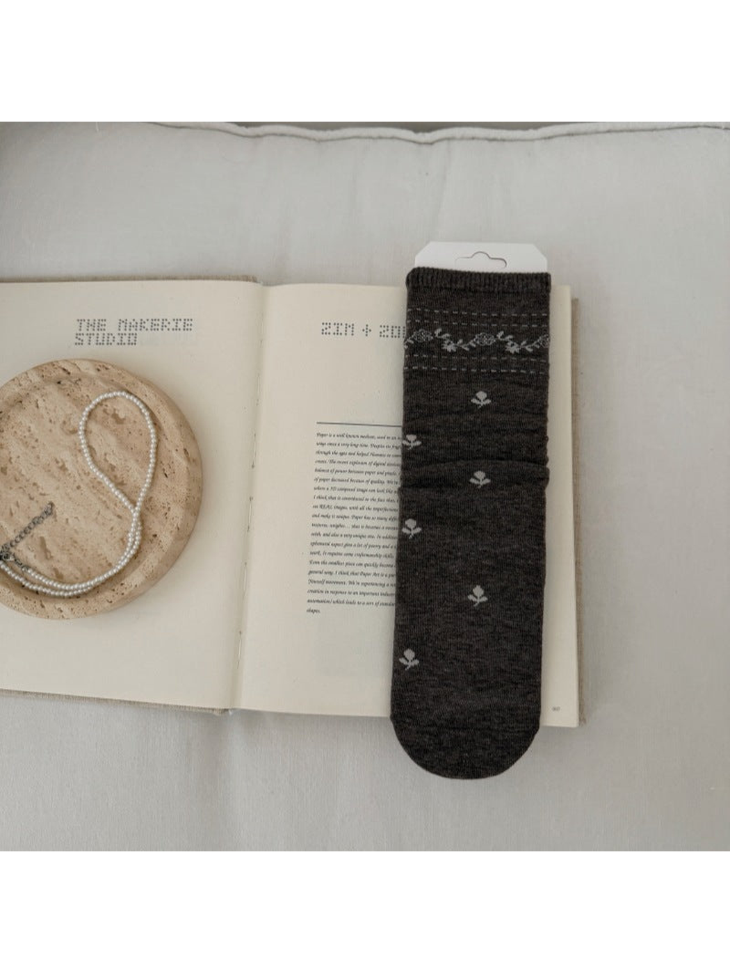 Brown sock with light floral sprigs and a patterned ribbed cuff.