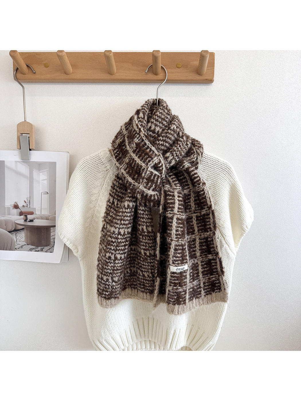 Brown plaid scarf looped and draped over a cream knit sweater, with cream grid lines and end borders.