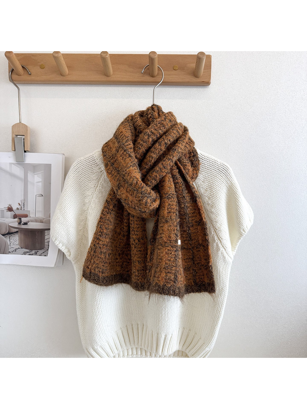 Caramel plaid scarf looped and draped over a cream knit sweater, with dark grid lines and end borders.