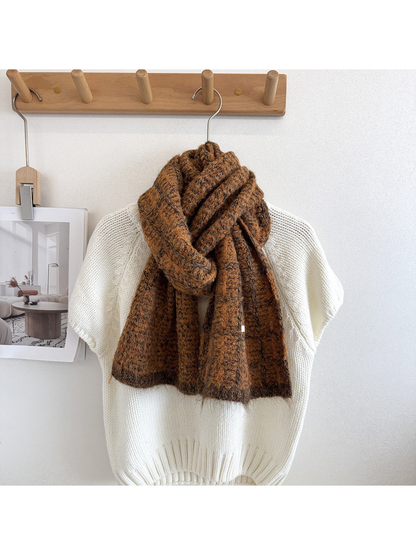Caramel plaid scarf looped and draped over a cream knit sweater, with dark grid lines and end borders.