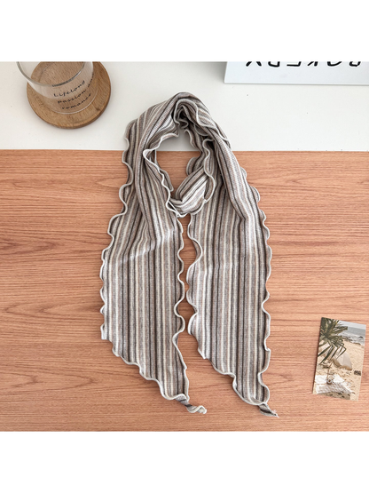Beige striped scarf arranged in a loop with wavy edges and pointed ends.