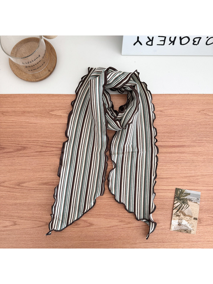 Green striped scarf arranged in a loop with wavy brown edges and pointed ends.