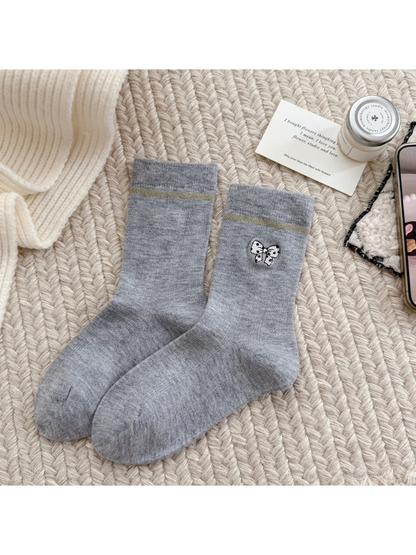 Light gray socks with a spotted bow motif, contrasting cuff stripes and ribbed cuffs.