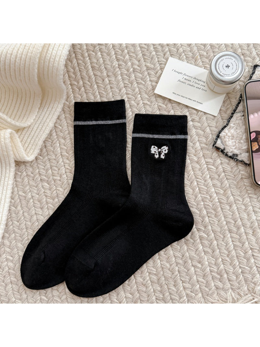 Black socks with a spotted bow motif, gray cuff stripes and ribbed cuffs.