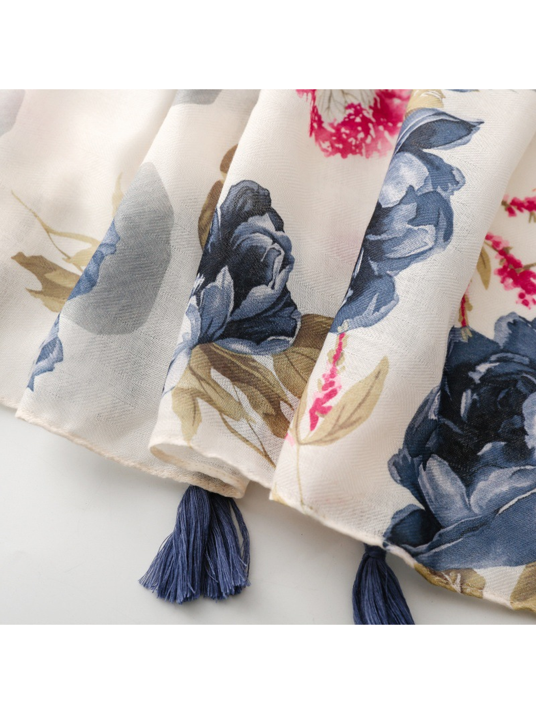 Close-up of navy floral motifs, narrow hem and navy tassels