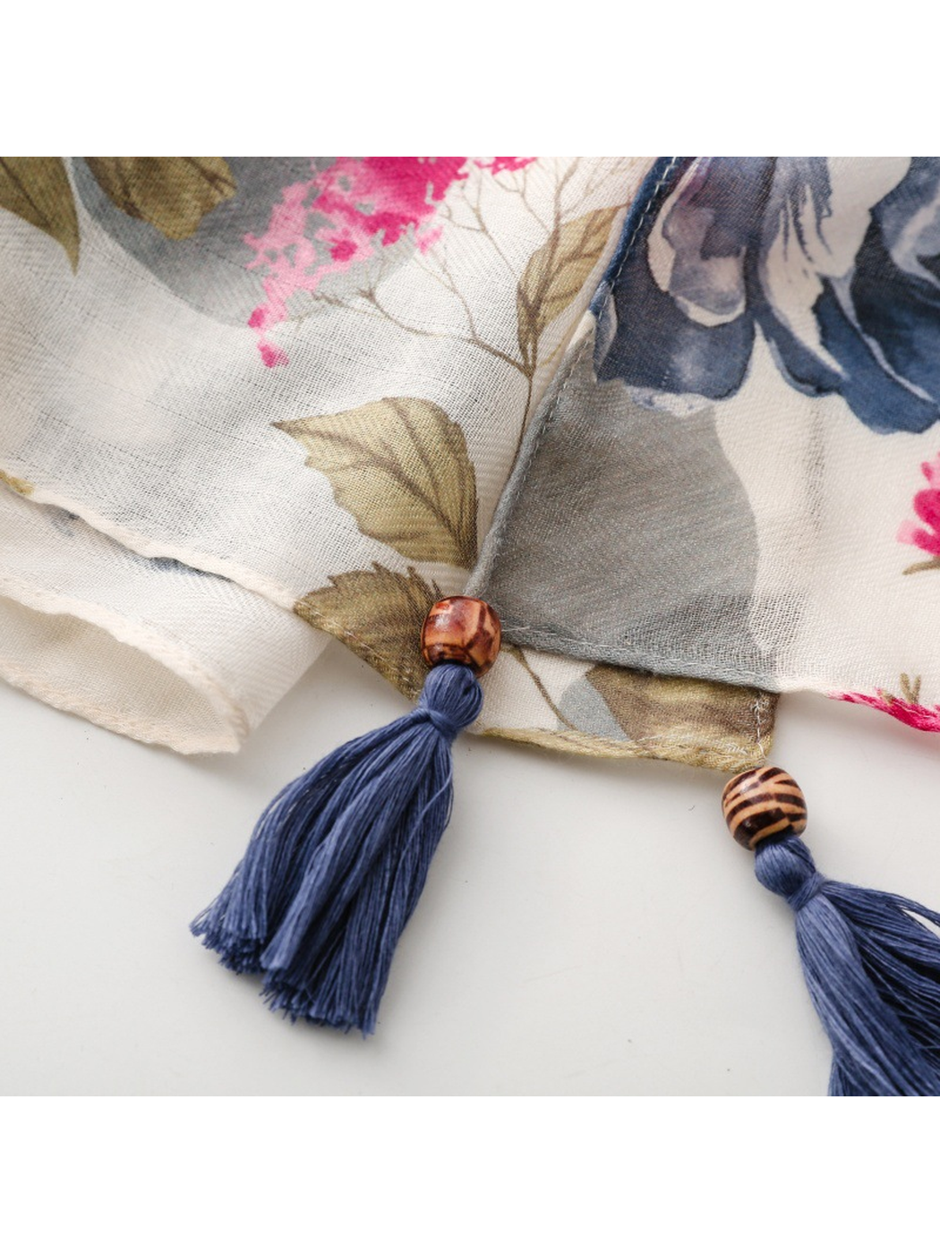 Close-up of two navy scarf tassels with patterned round bead accents
