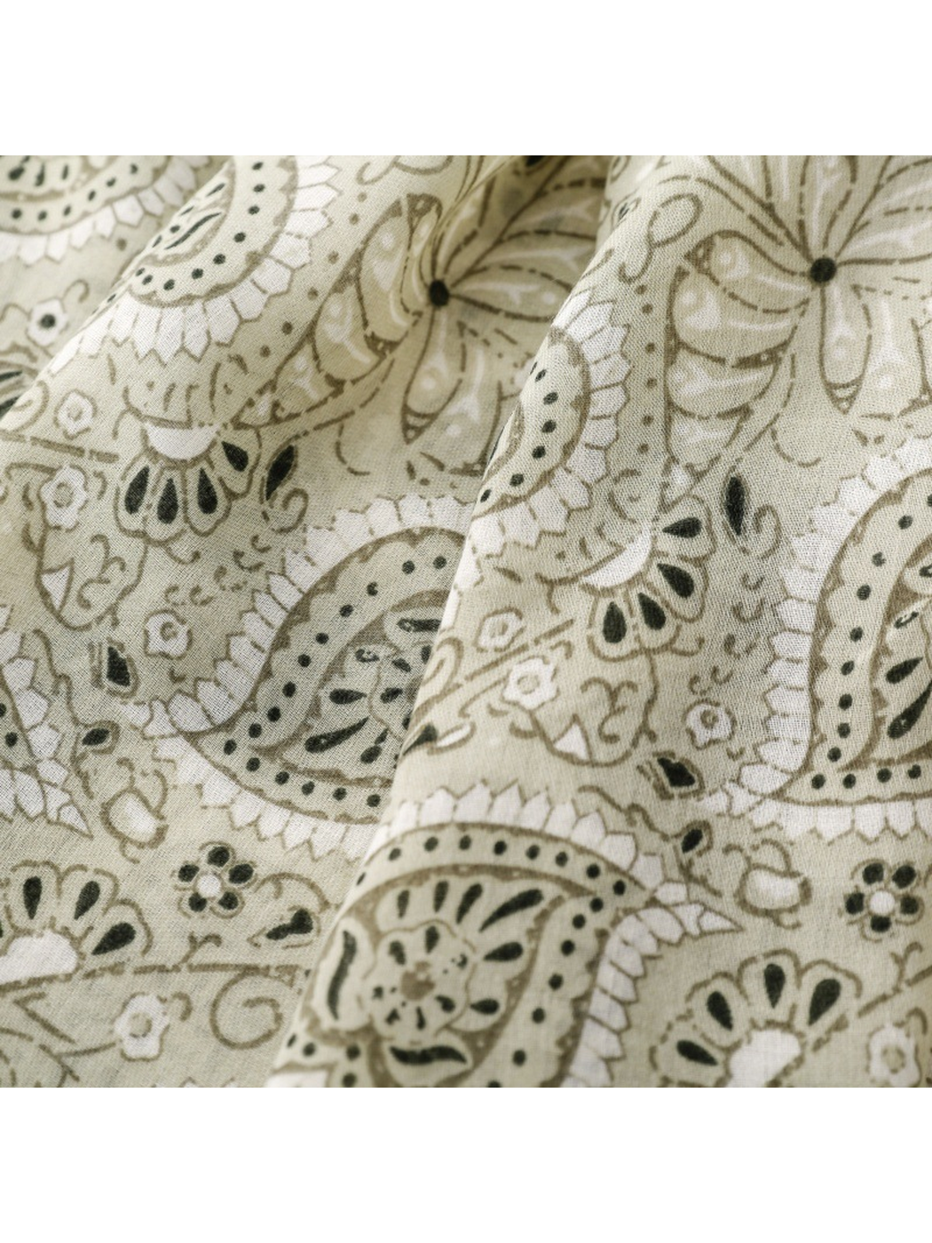 Close-up of sage green paisley, butterfly and small floral motifs on the scarf