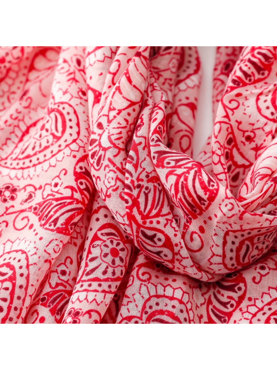 Close-up of the red paisley scarf print and fine woven texture in looped folds