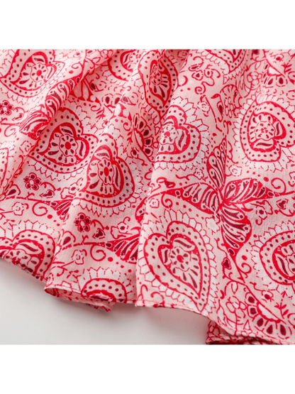 Close-up of the red paisley and butterfly print extending to the narrow stitched hem