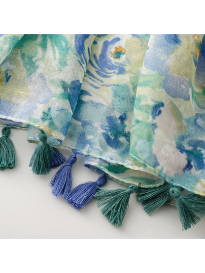 Close-up of alternating blue and green tassels along the scarf's stitched edge