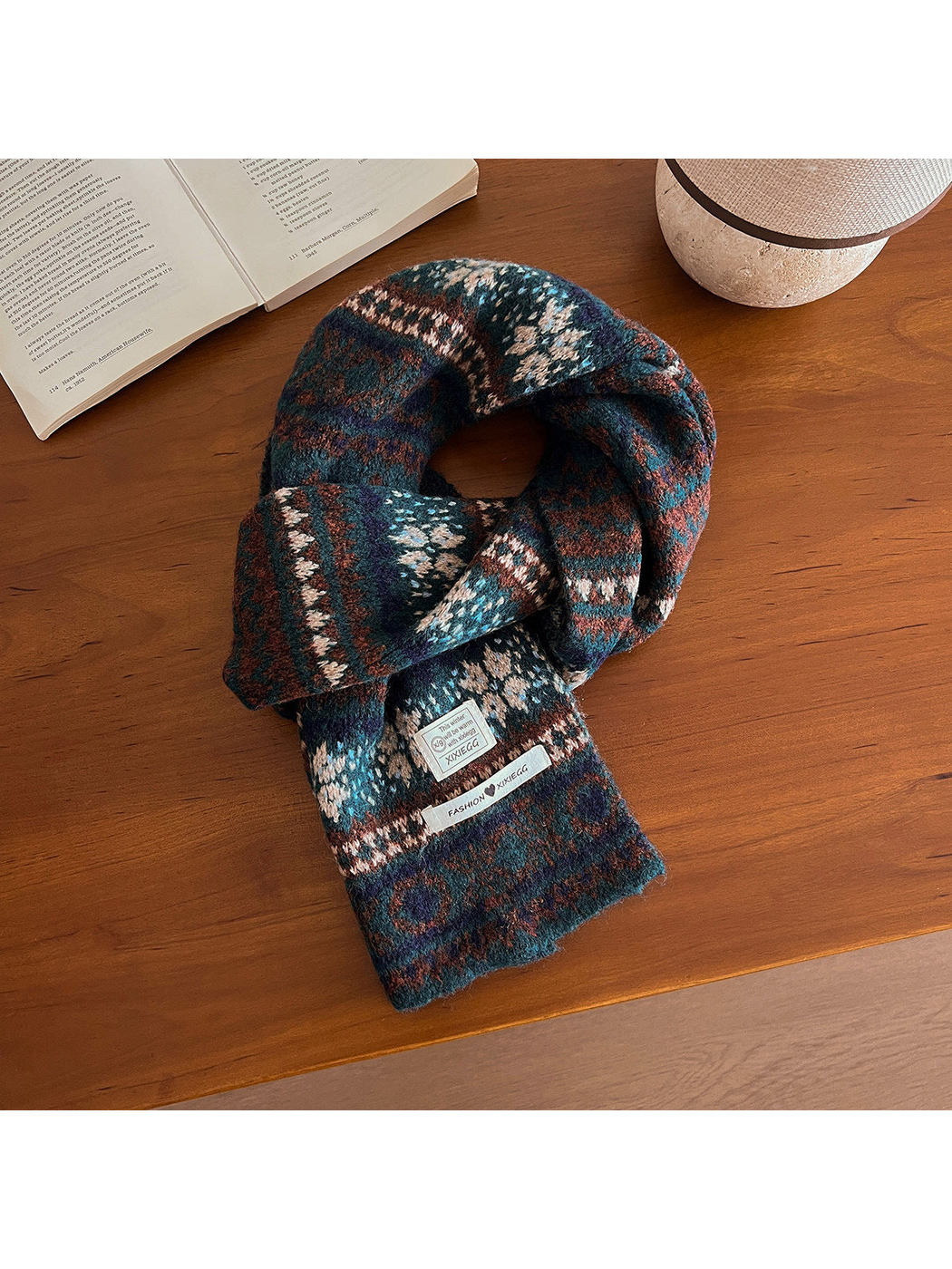 Deep teal and navy geometric-pattern scarf arranged on a wooden table
