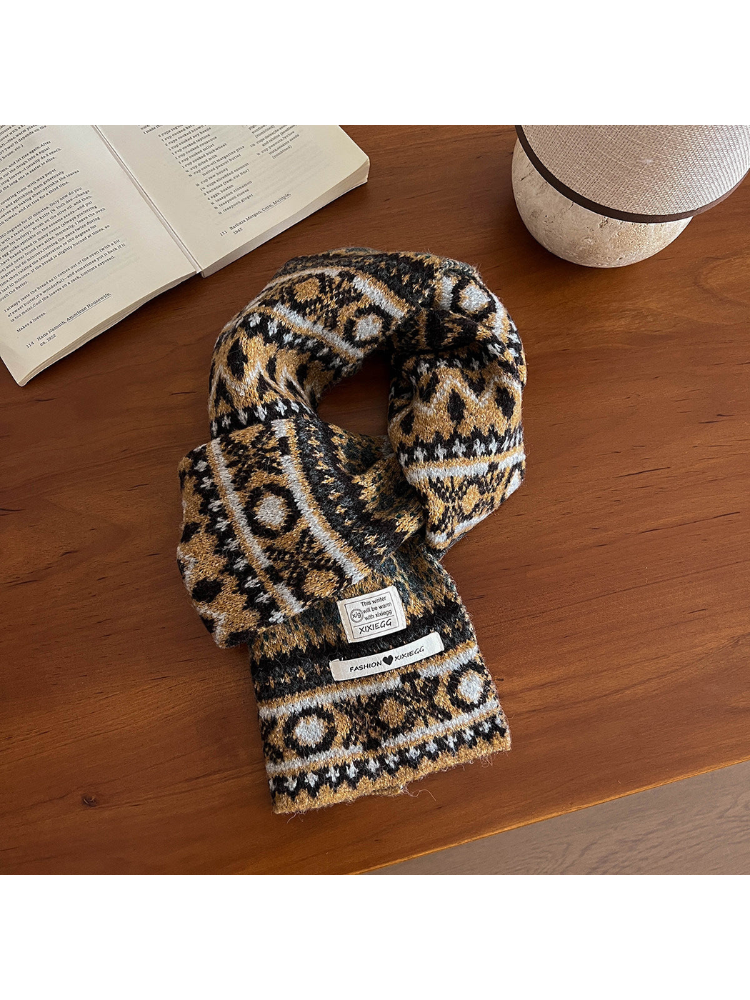 Mustard yellow geometric-pattern scarf arranged on a wooden table