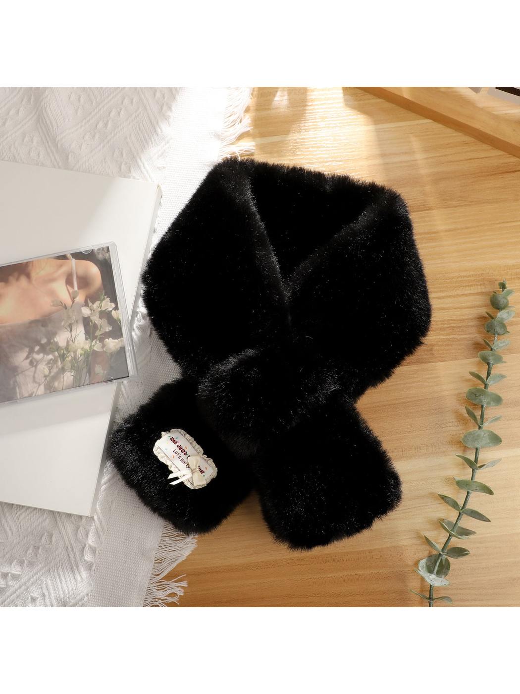 Black fuzzy pull-through scarf with decorative bow patch