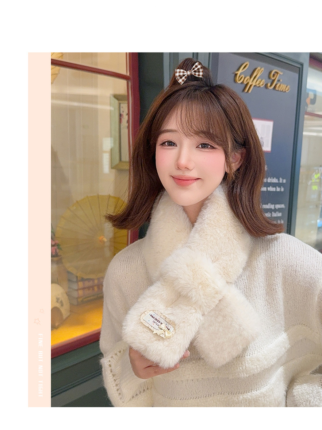 Off-white fuzzy pull-through scarf worn with one hand holding the decorated end