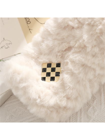 Close-up of the black-and-gold checker accent on a white fuzzy scarf