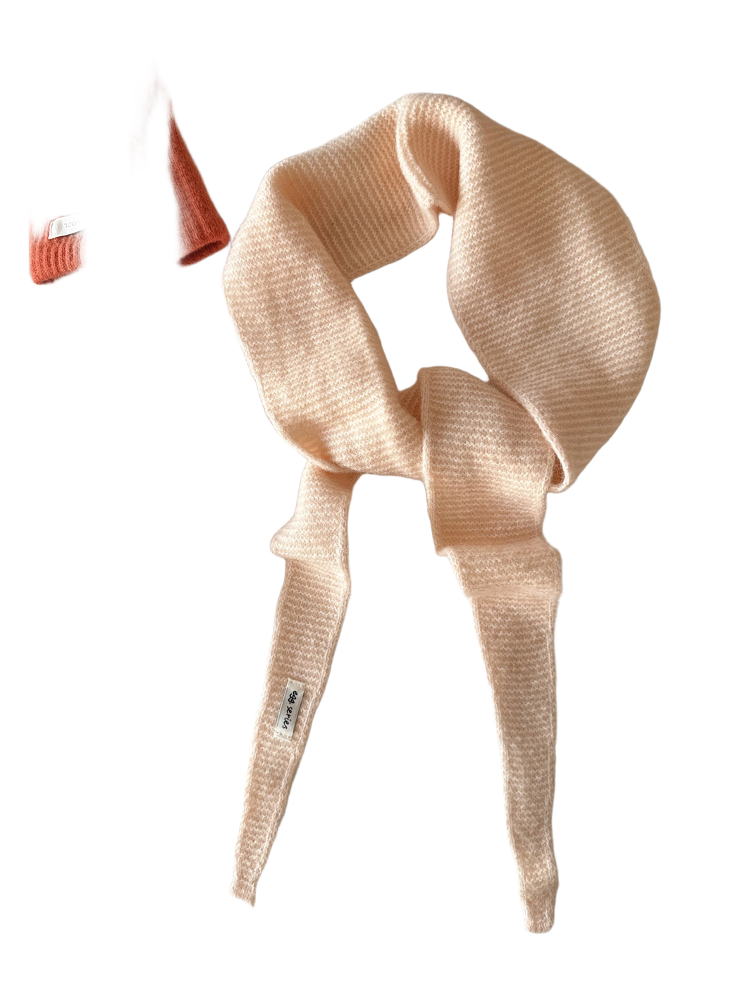 Blush beige textured narrow scarf with tapered ends arranged in a loose knot