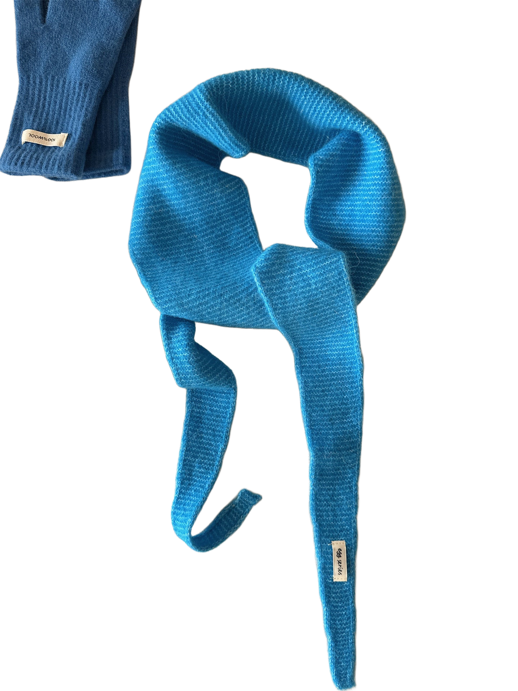 Bright blue textured narrow scarf with tapered ends arranged in a loose knot