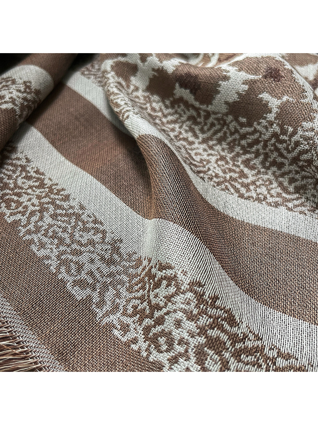 Close-up of the brown striped border, woven pattern and fringe