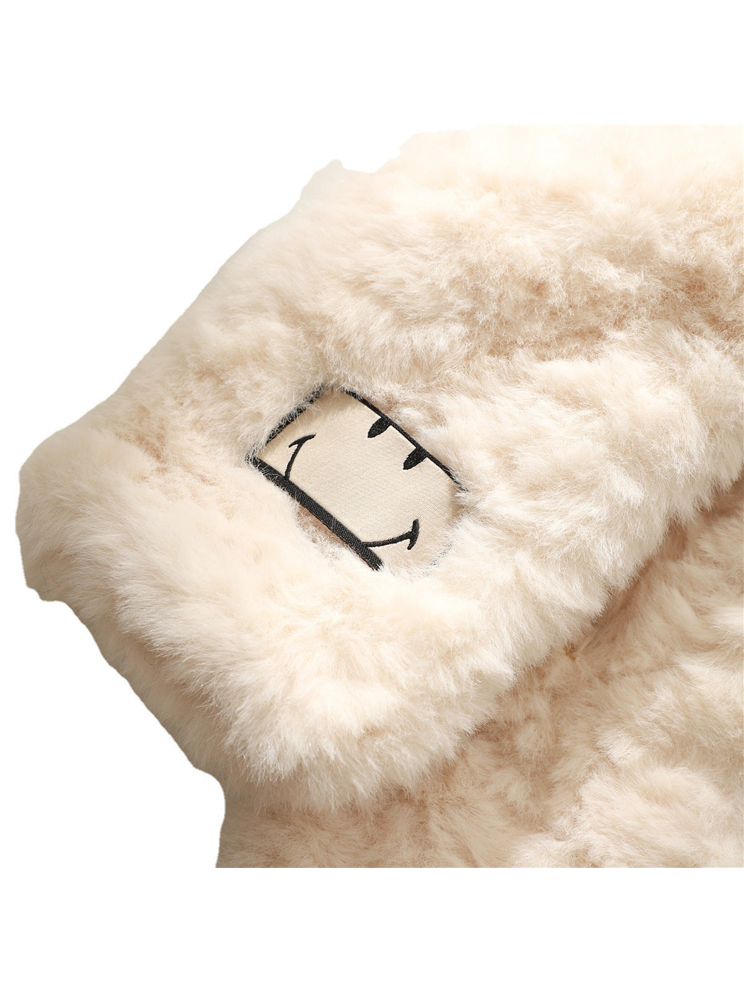 Close-up of the fuzzy cream scarf and outlined smiling face patch
