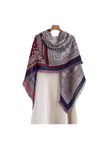 Paisley square scarf draped asymmetrically over a light dress