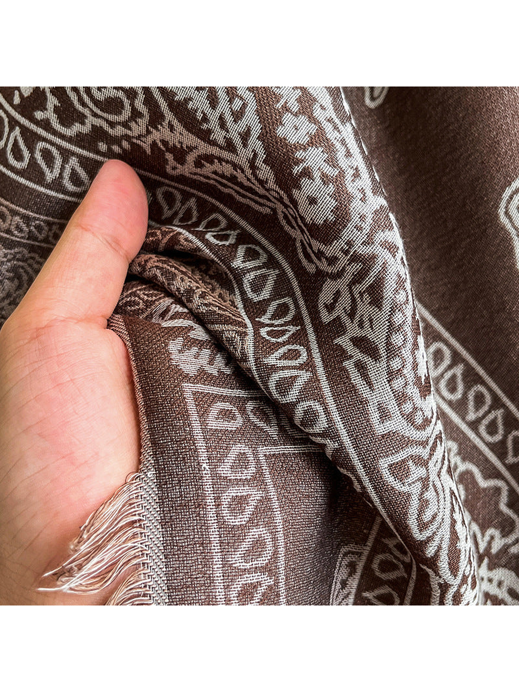 Close-up of the fine woven paisley pattern and short fringed edge