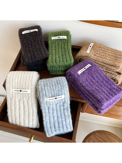 Six fuzzy ribbed scarf colors arranged together in a wooden drawer