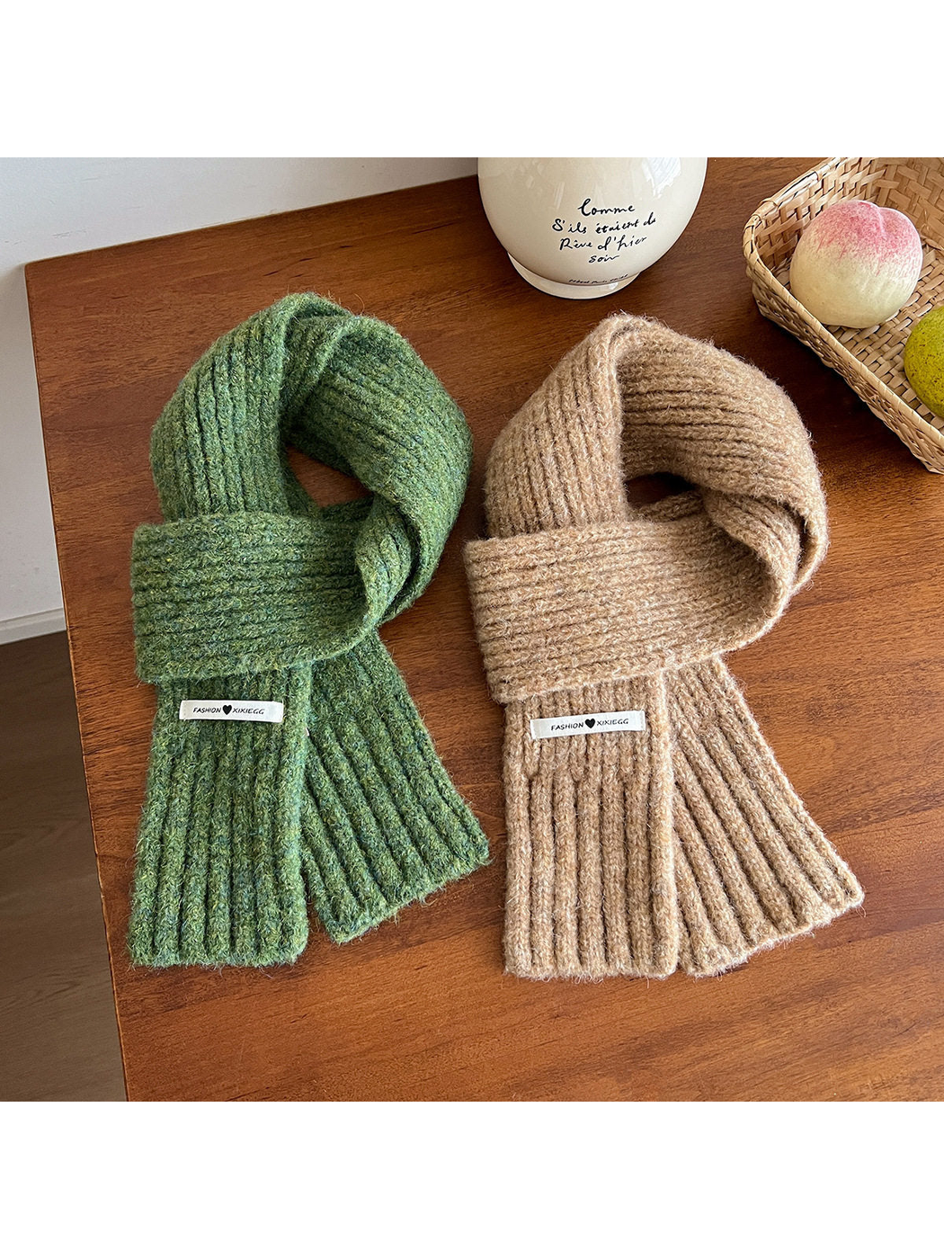 Green and camel ribbed scarves arranged on a wooden table