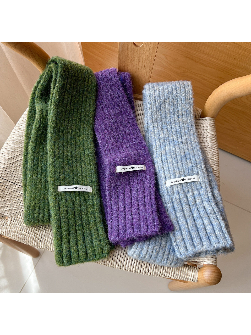 Green, purple and gray-blue ribbed scarves draped over a chair