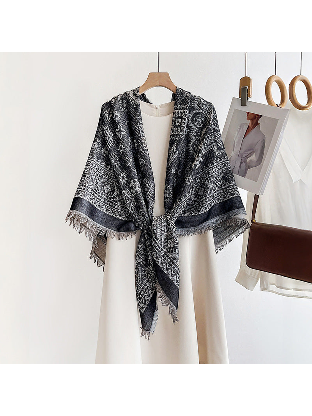Black geometric square scarf tied over a cream dress