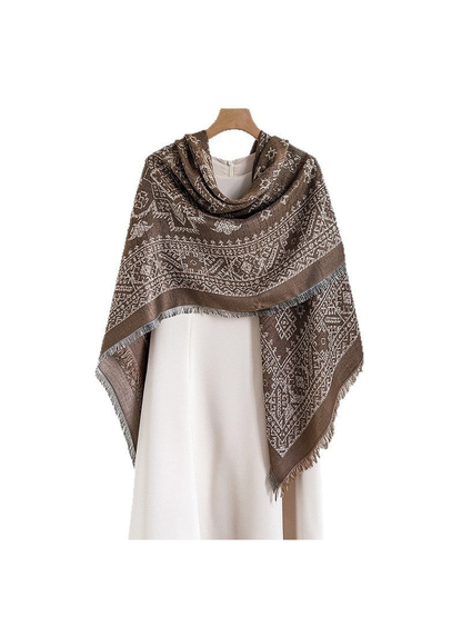 Brown geometric square scarf draped asymmetrically over a cream dress