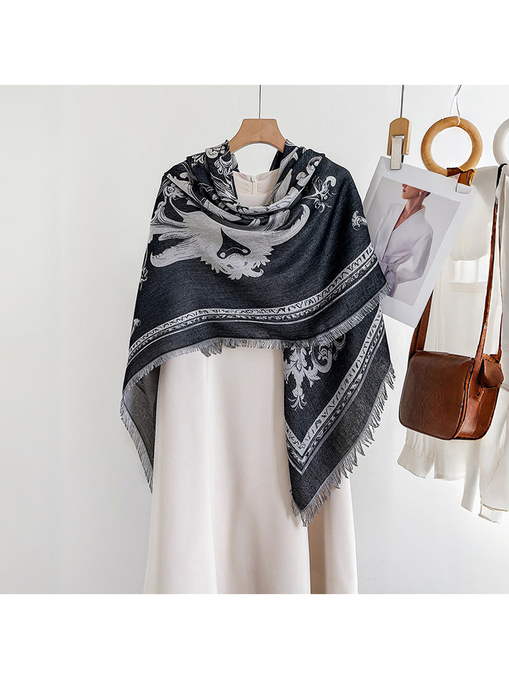 Black ornamental square scarf draped over a dress form