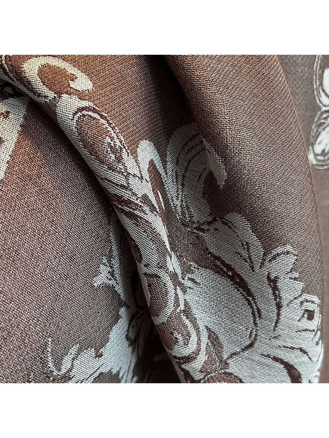 Close-up of the brown scarf's woven surface and ornamental pattern