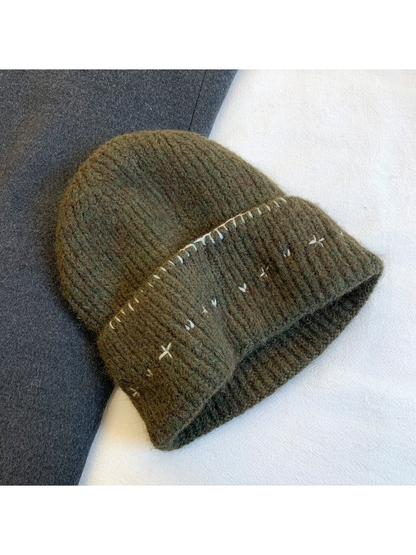Olive green fuzzy ribbed beanie with contrasting stitched motifs