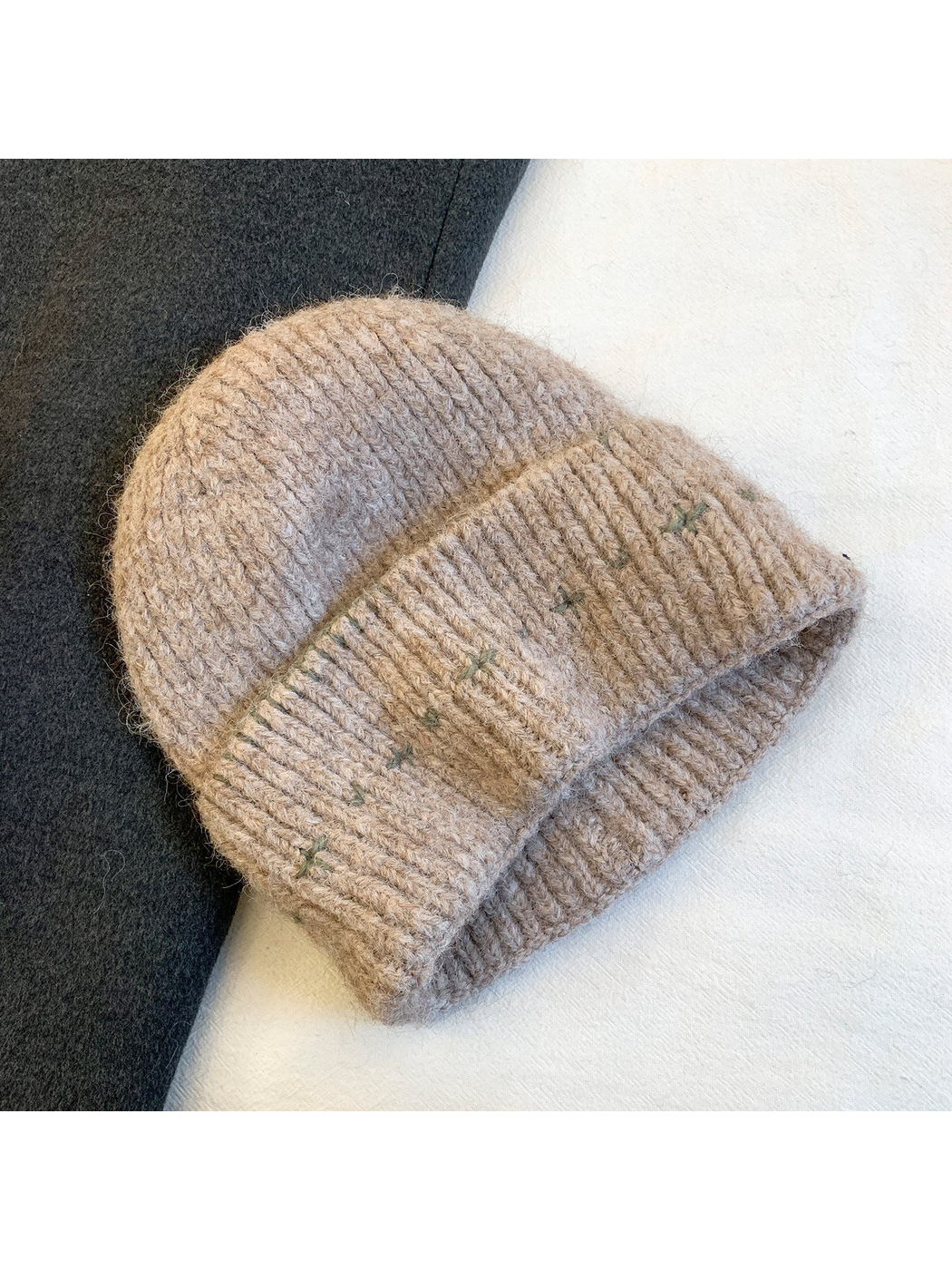 Oatmeal fuzzy ribbed beanie with green stitched motifs