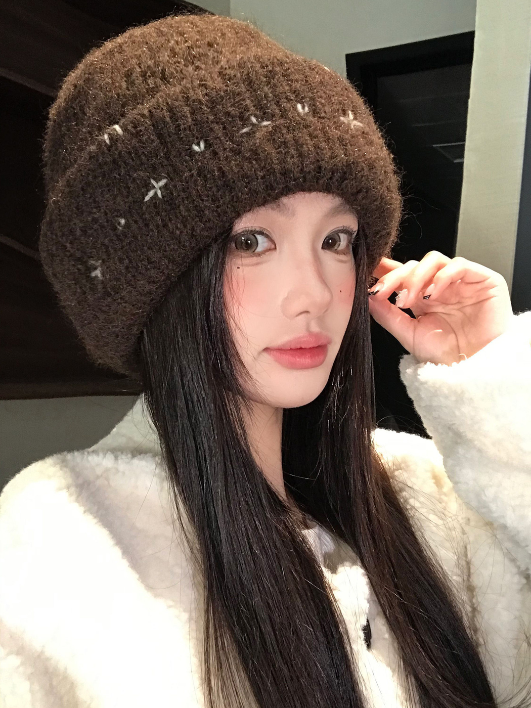 Brown fuzzy ribbed beanie with stitched motifs, vertical worn view