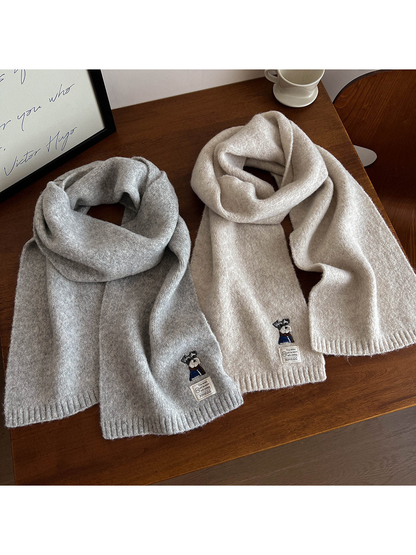 Light gray and ivory scarves arranged lengthwise with embroidered dog motifs