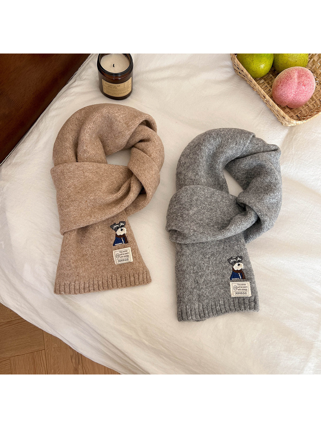 Khaki and light gray scarves arranged in knotted loops on a white surface