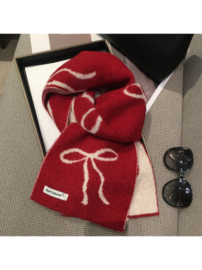 Red scarf with cream bow motifs, draped view