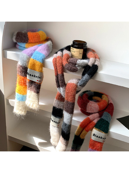 Three fuzzy color-block scarf variations arranged together on white shelves