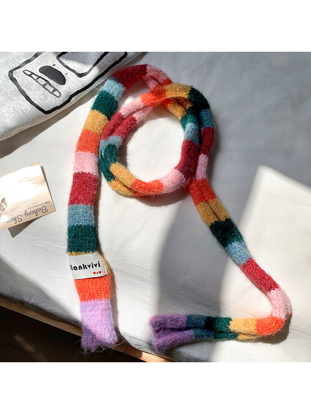 Red, pink, green and orange fuzzy color-block scarf arranged in a long loop