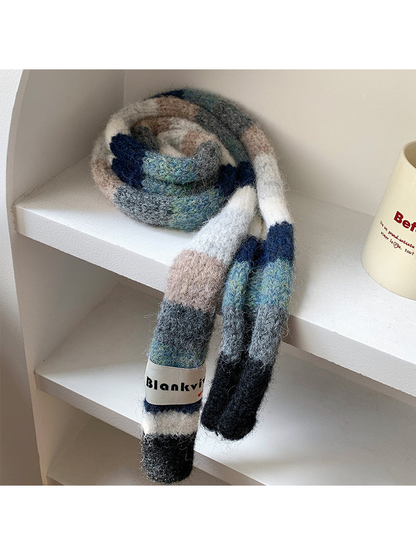 Navy, gray and beige fuzzy color-block scarf coiled and draped on a shelf